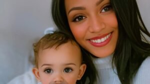 Mother and toddler smiling together on a couch, wearing cozy sweaters with bee and flower embroidery, symbolizing warmth, growth, and modern motherhood